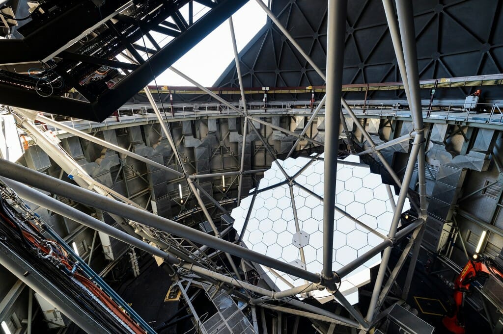 Many intersecting beams and rods inside the telescope above a massive mirror