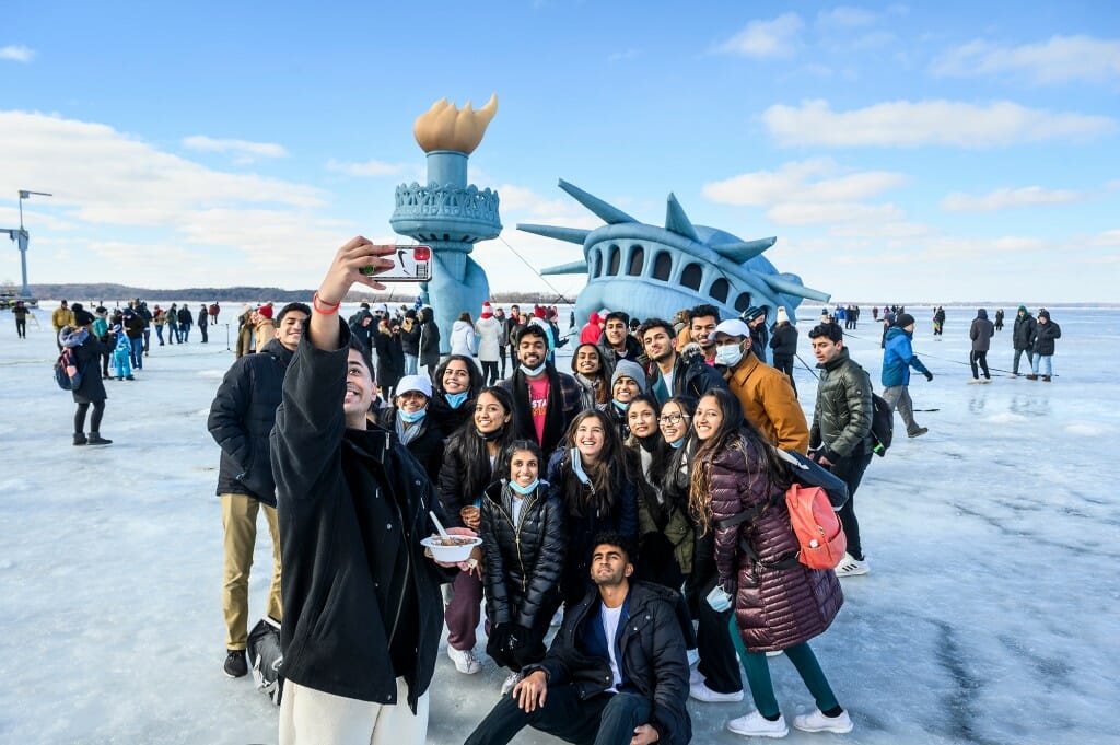 UW student Abhishek Joshi takes a photo of Pitt Mastana, a competitive bollywood-fusion dance team from the University of Pittsburgh, as its members pose with an inflatable replica of the Statue of Liberty on frozen Lake Mendota.