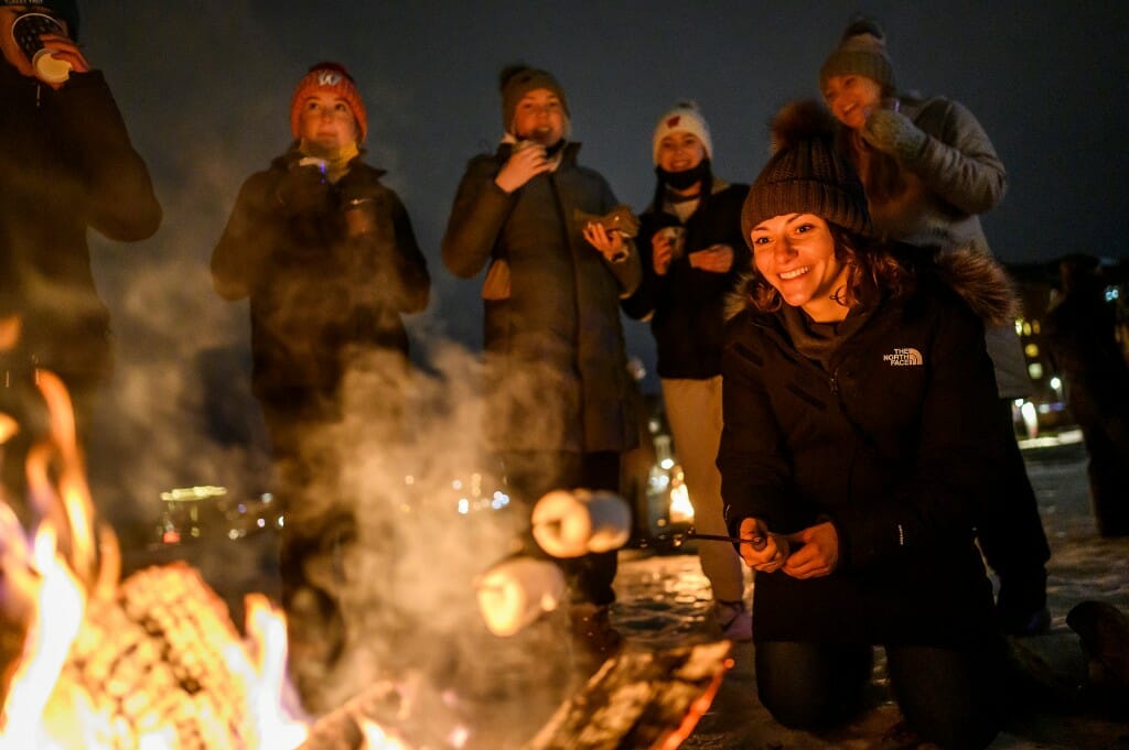 Student Sarah LaBorde roasts five marshmallows at once to make s’mores over a bonfire on frozen Lake Mendota as part of the annual Wisconsin Union Winter Carnival.