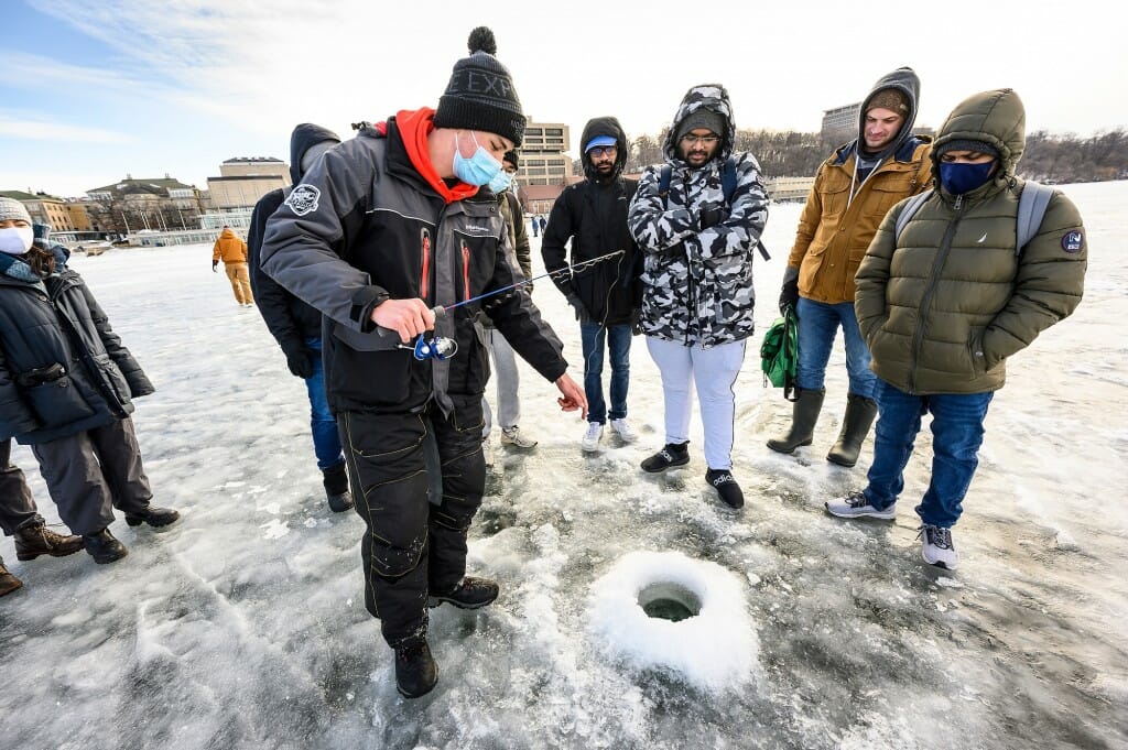 Andrew Meyers of the Wisconsin Fishing Team teaches a group of students how to ice fish at the first-ever educational Ice Fishing Derby on Lake Mendota near the Memorial Union Terrace.