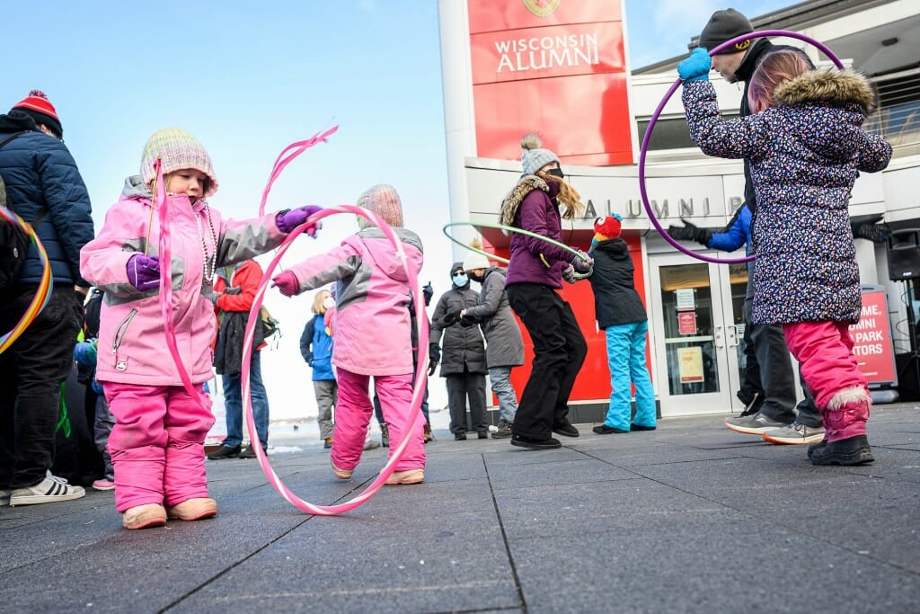 Alaina Brien (left) and other children twirl hula hoops and wave ribbons to the music of DJ Mike Carlson during the Winter Carnival’s Family Fun in Alumni Park and One University Place.