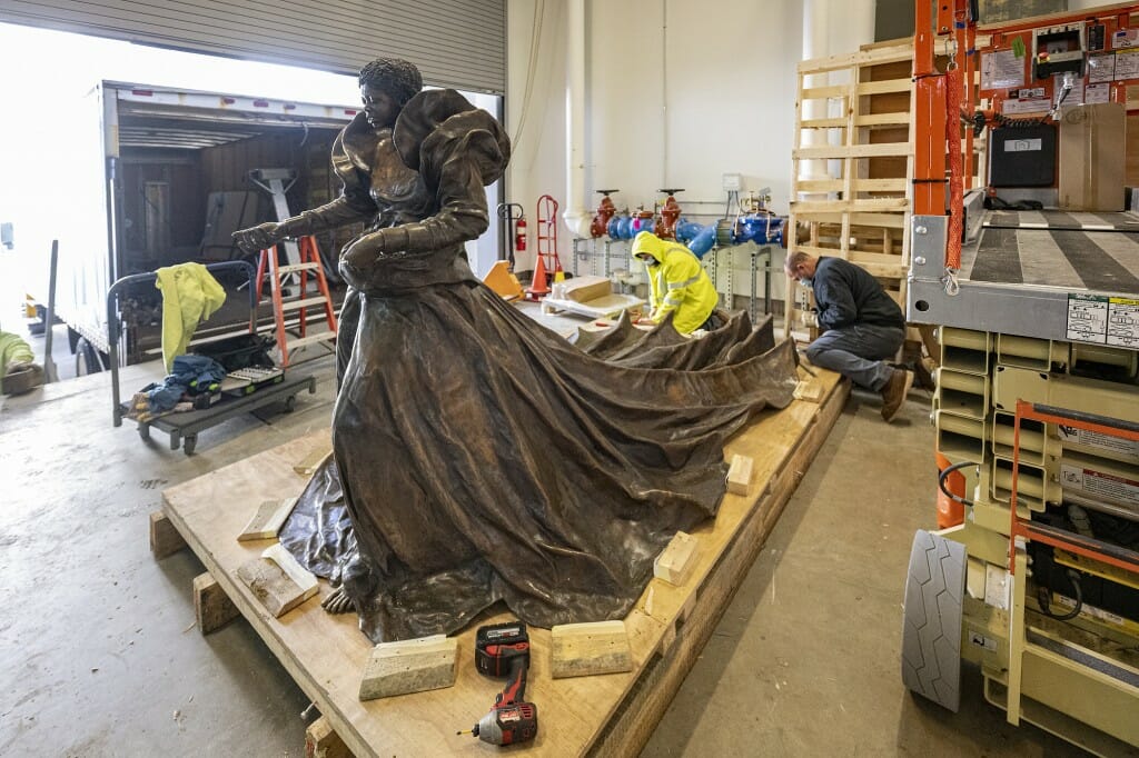 View of the entire statue, depicting a Black woman in a flowing dress