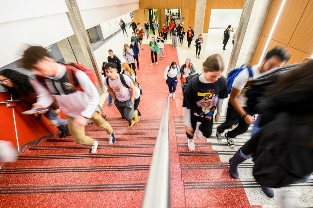 Students walking up a red and white stairway