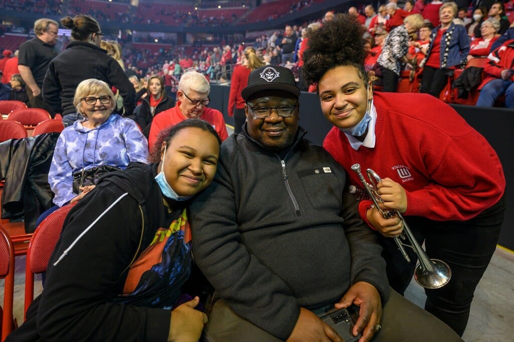 At right, UW band member and trumpet player Jaida Salaam greets her father Hakim Salaam and sister Avayah Salaam at intermission.