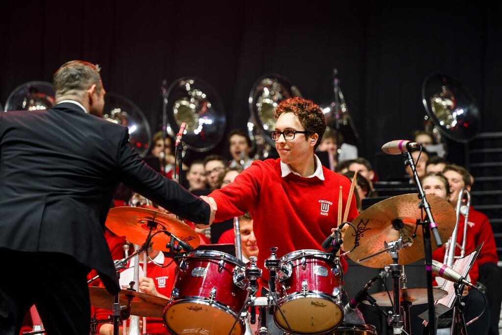 At center, Abe Stoeffel Murray shakes hands with UW Marching Band Percussion Coordinator Matthew Endres, after completing an epic drums solo. Endres had just conducted a standalone number: “Boogie Boogie Bugle Boy.