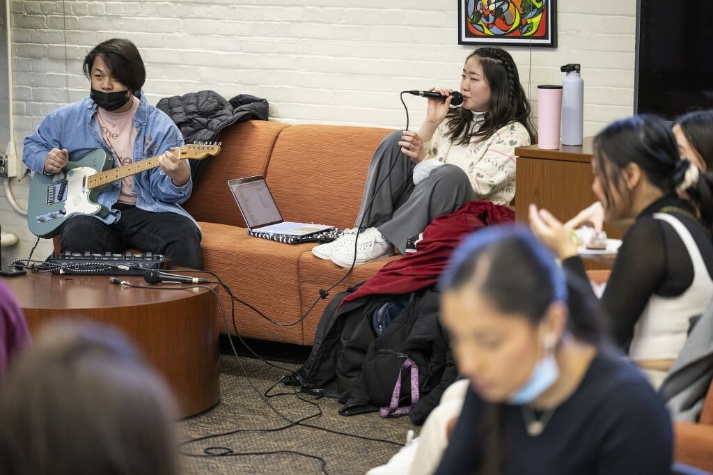 Student musicians Sebasian Yang on guitar and Haruka Ishii on vocals perform.