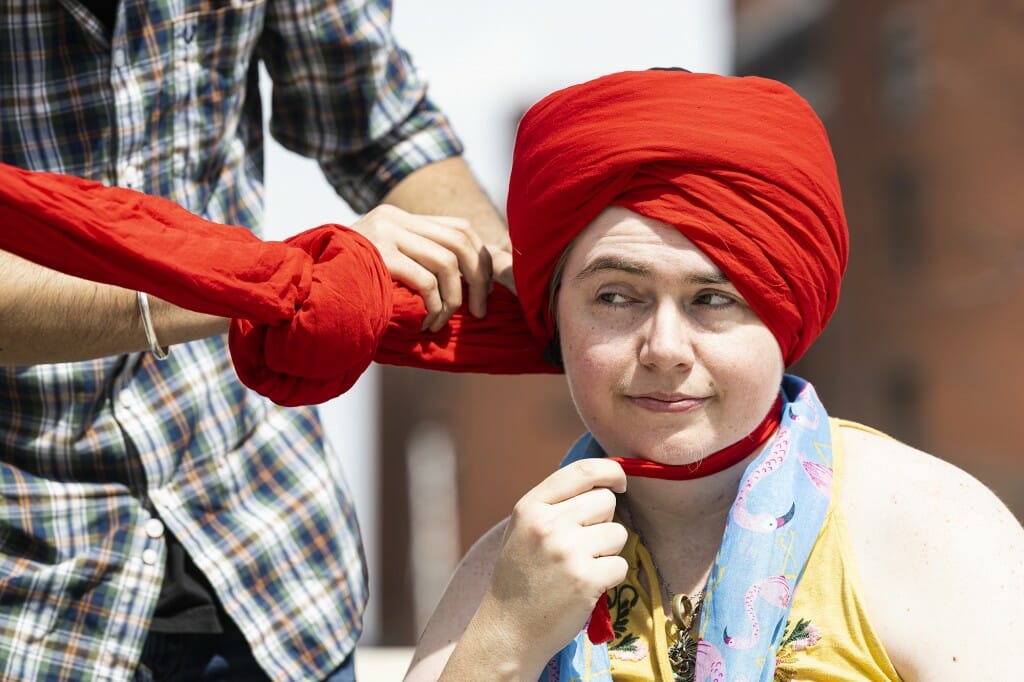 Madison resident Landyn Record helps out with turban tying.