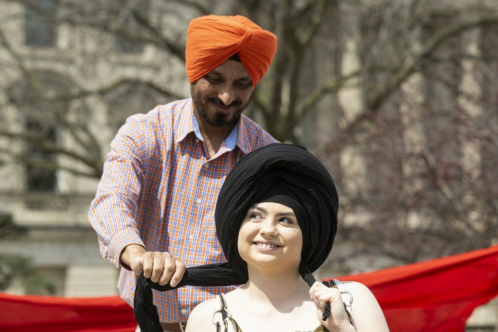 UW alum Gursharan Singh (left) ties a turban on a participant, who seems pleased with it.
