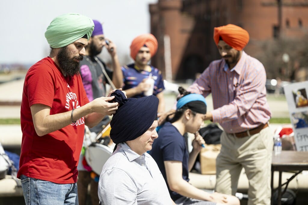 UW student Manmeet Singh Dang (left) and UW alum Gursharan Singh (right) demonstrate the technique of properly tying turbans.