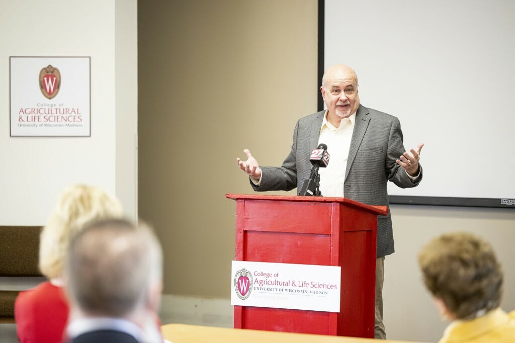 Mark Pocan speaking at a podium inside a conference room