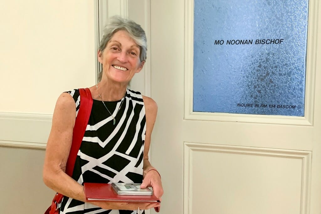 Mo Bischof standing in front of an office door with her name on the window