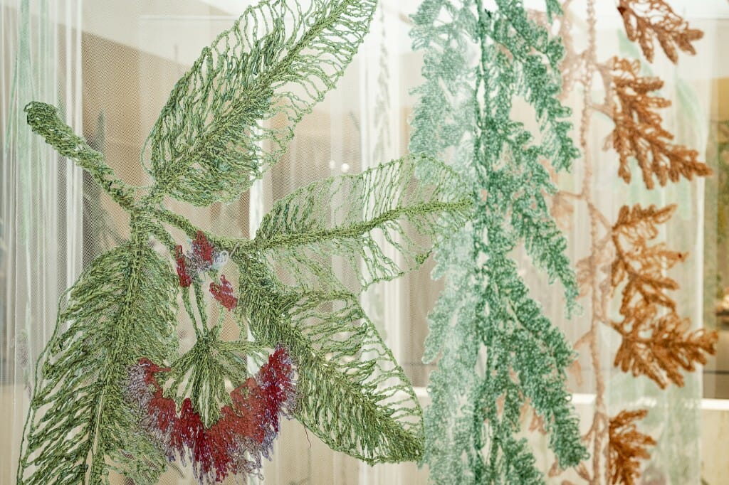 Closeup of large embroidered plants hanging from ceiling