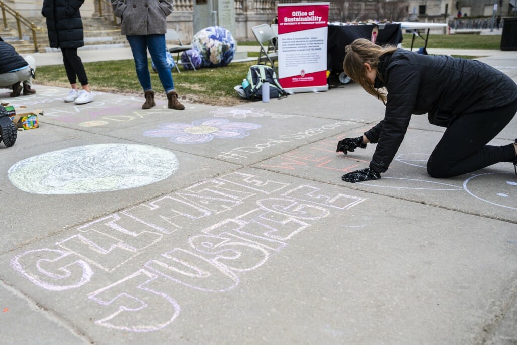 Students and community members chalk the sidewalk to drum up excitement for Earth Week.
