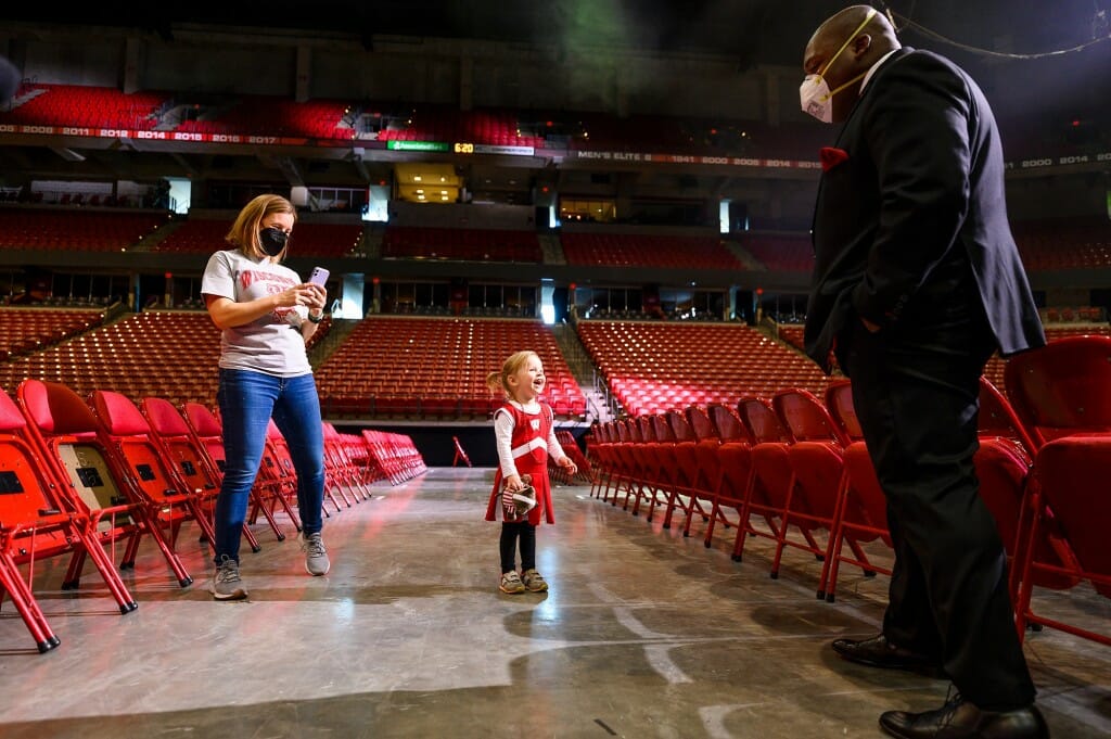 Ila greets UW band director Corey Pompey at the dress rehearsal of the UW Varsity Band Spring Concert in the Kohl Center.
