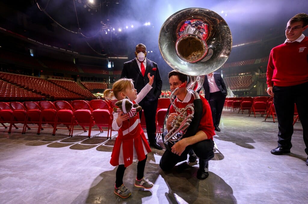 Ila wonders if her stuffed toy Bucky would fit in the sousaphone’s bell of Josh Richlen, drum major and tuba player.