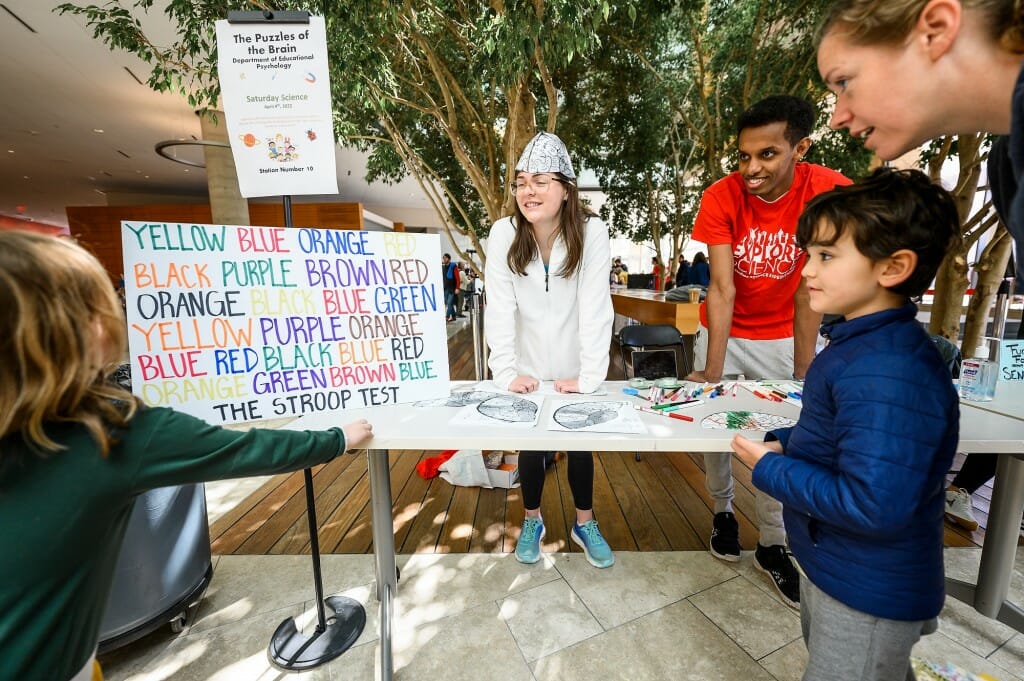 Children try the Stroop Color and Word Test, which is reading the names of colors written in ink of a different color, at a station on “The Puzzles of Brains” run by the Department of Educational Psychology  in the Discovery Building.