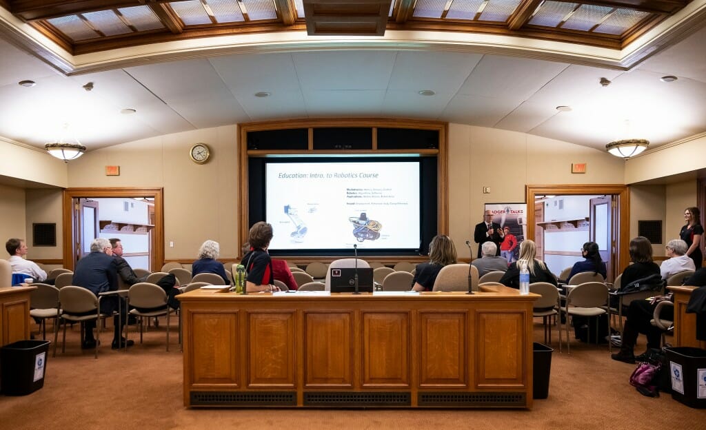 Wide view of the room in which the flash talk took place, showing wood-paneled desks and skylights