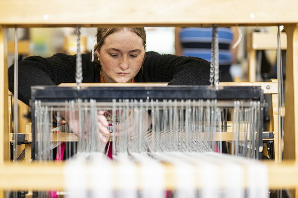 Student Savannah Nielson discovers the complexities of the weaving loom.