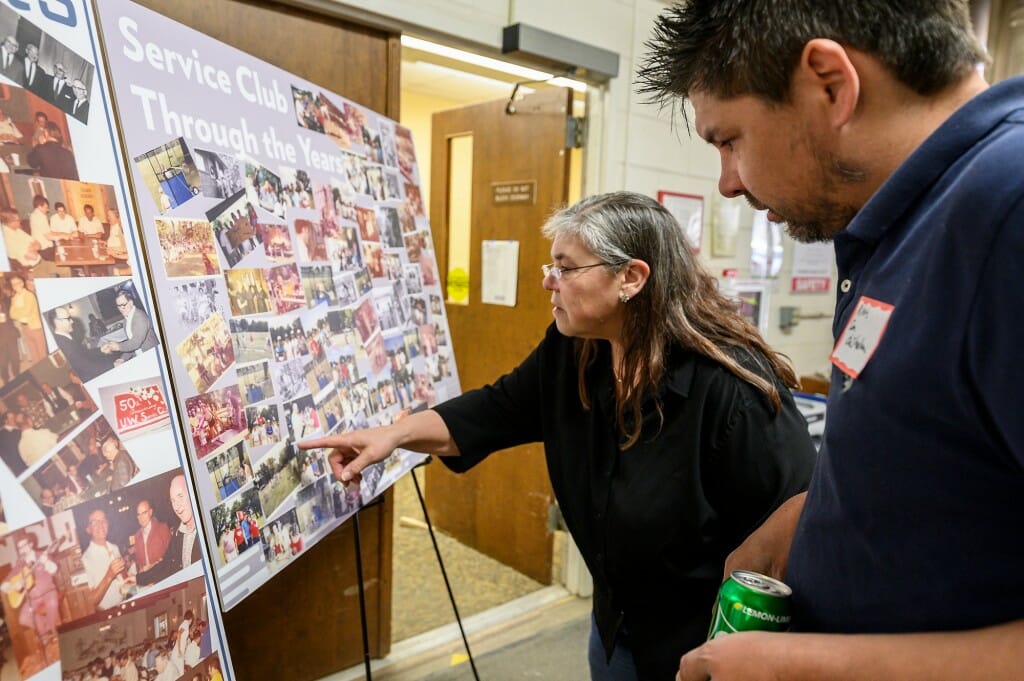 Irma Smith and Mitch Smith, daughter and grandson of retired UW electrician Don Chisholm, look through a retrospective photo board at the event.