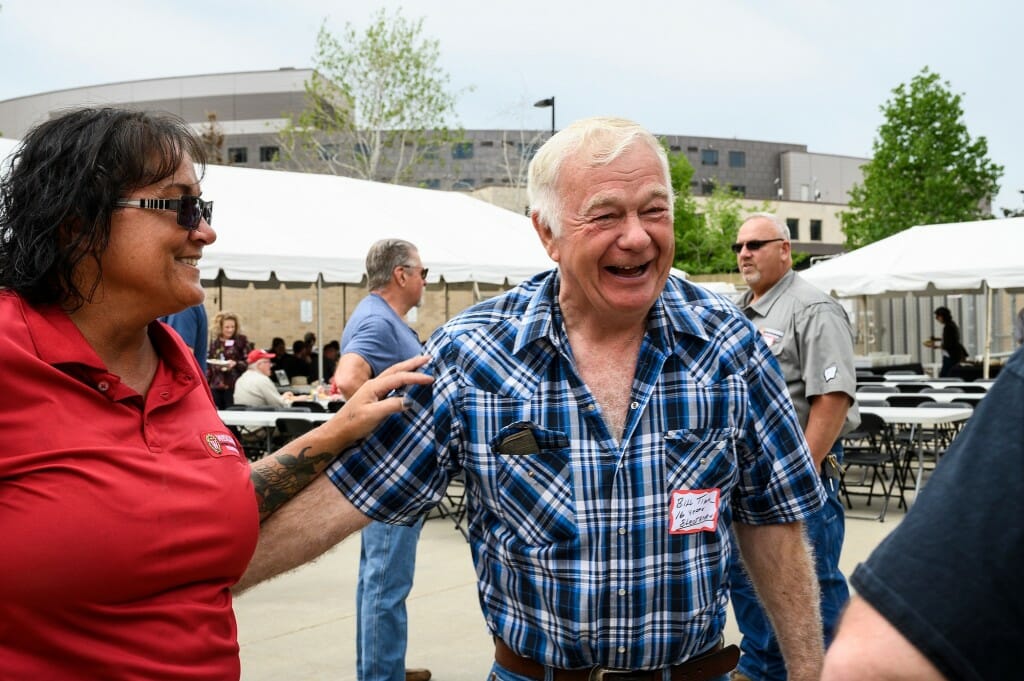 Two men smile and laugh together.