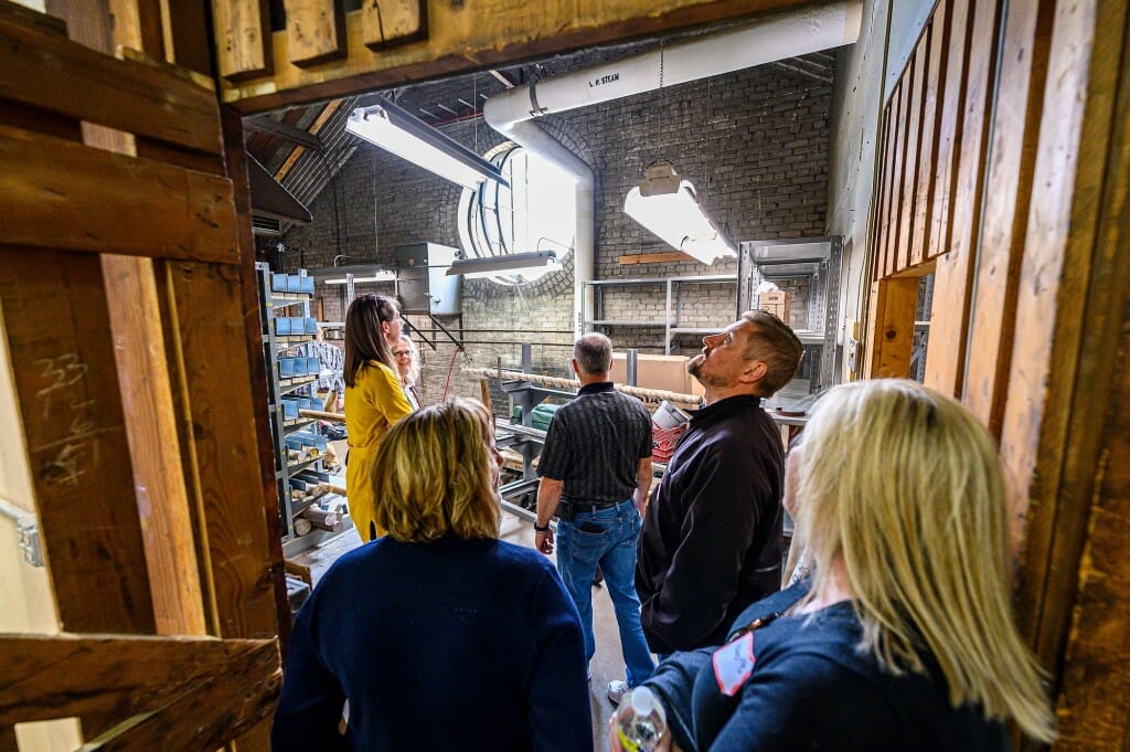 A crowd of people look at the exterior of a brown building.