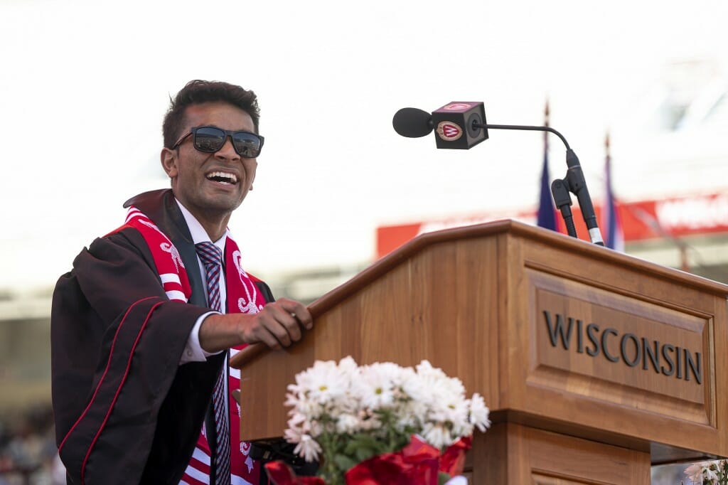 Pranav standing and smiling at podium