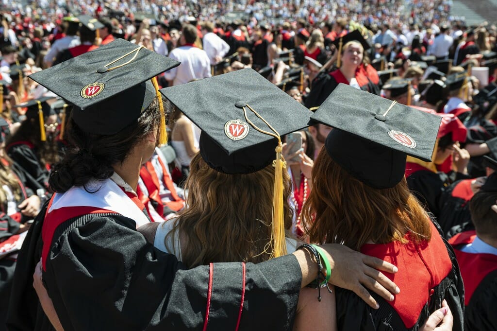 Three people in mortarboards as seen from behind