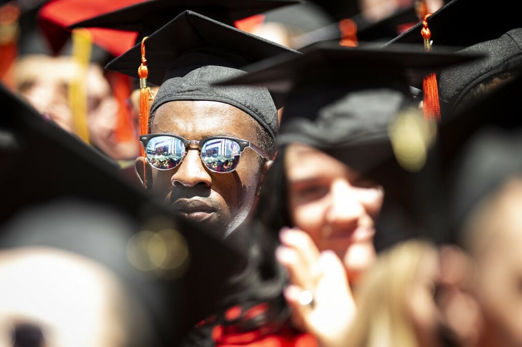 Closeup of a person wearing a mortarboard and sunglasses