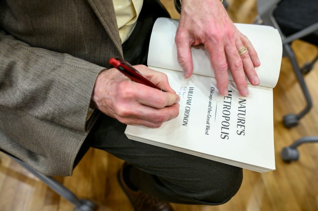 Closeup of Cronin's hand signing the title page of a book
