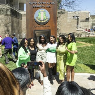 At the Divine Nine Garden Plaza, members of the Alpha Kappa Alpha Sorority, Inc., celebrate and take photos in front of their plaque.