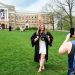 Soon-to-be-graduate Makenna Ley poses on Bascom Hill with her gown and decorated neurobiology and biochemistry motarboard hat while Liza Spellman take photos.