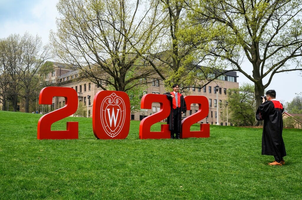 Soon-to-be industrial engineering graduate Dingsheng Tao poses with the numerals “2022” while Nicholas Tam takes his photo.