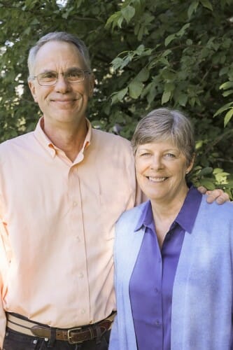 Portrait of Jocelyn Milner and Mark Ediger standing in front of a leafy background