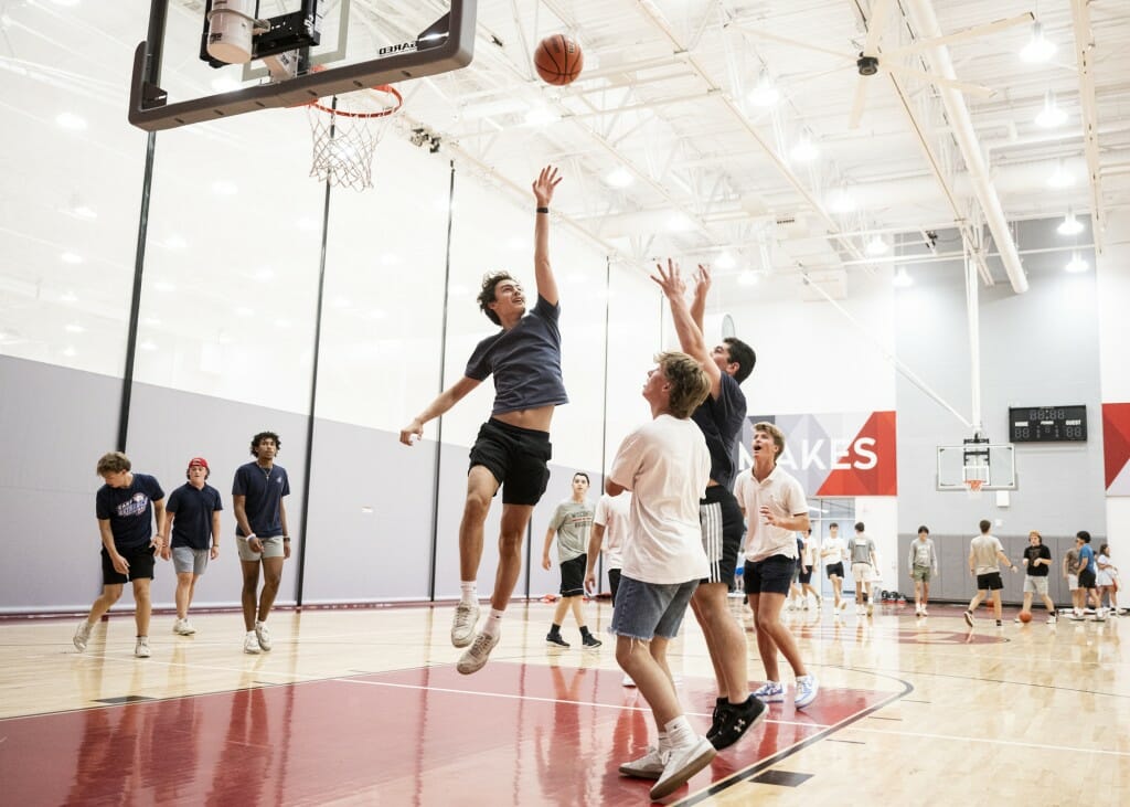 Students play basketball on a court.