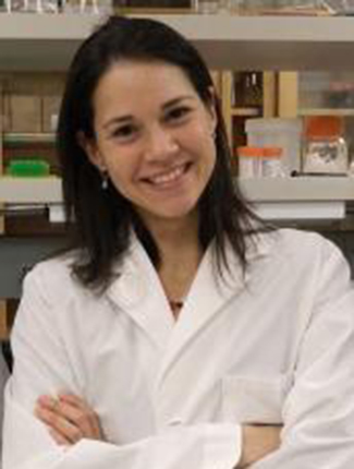 Portrait of Wilmara Salgado-Pabón in lab coat in front of lab shelves