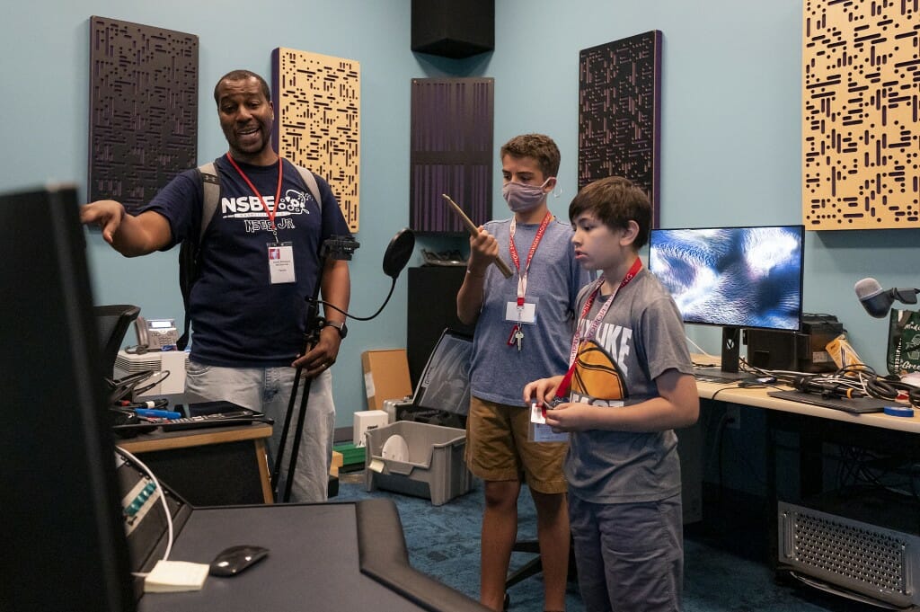 The instructor for the Summer Music Clinic Junior Session class, Corey Whitmore, gives the middle school students a tour of the recording studio. 