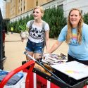 First-year student Cheyenne Schepp from Wausau holds a potted plant while her mom maneuvers the moving cart during the Dejope Residence Hall move-in.
