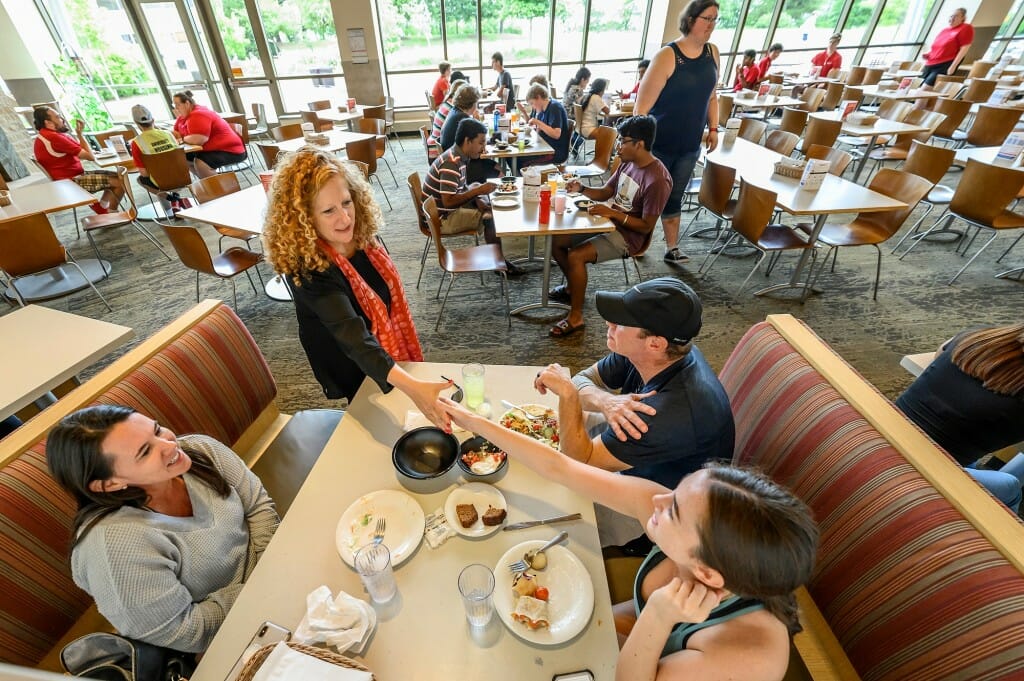 Chancellor Mnookin shakes hands with student Laurel Dorminy from Dallas, Texas, while her parents look on as they eat lunch outside of Four Lakes Market in the Dejope Residence Hall.