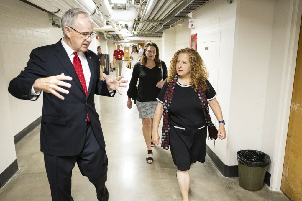 Jennifer Mnookin and Ian Robertson talk while walking down a hallway.