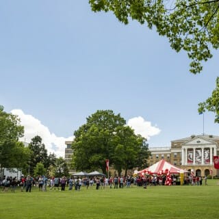 A distance shot of the ice cream tents, the people celebrating, with Bascom Hall in the background.