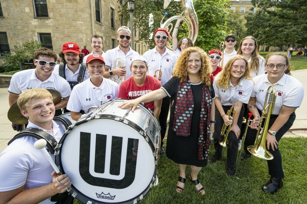 Chancellor Mnookin stands with some musicians holding instruments and a bass drum.