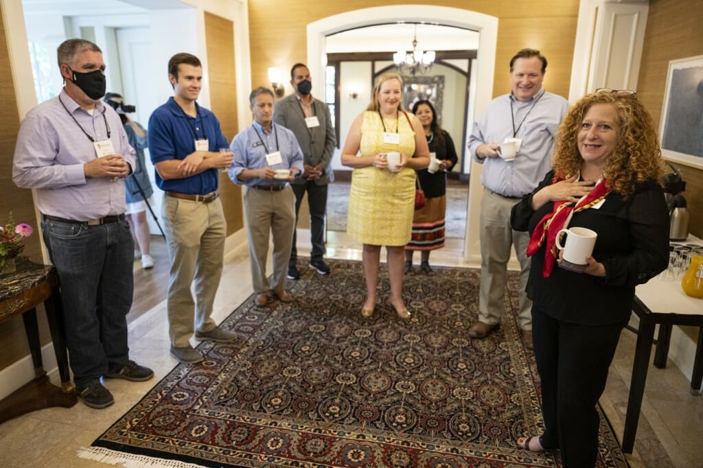 Chancellor Mnookin stands in a hallway as she speaks with a group of elected officials