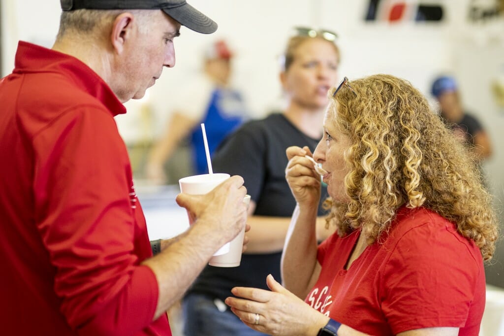 Chancellor Jennifer Mnookin tastes an ice cream shake with her husband, Joshua Foa Dienstag, while visiting with members of the local 4-H Club and UW Extension.