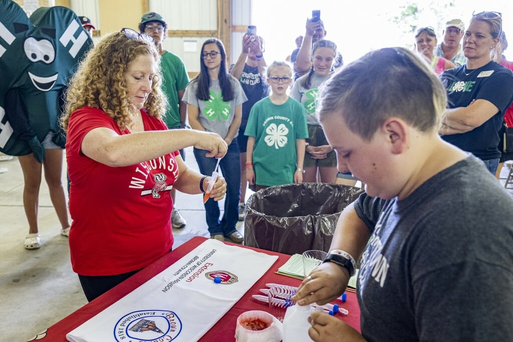 Chancellor Mnookin participates in a science experiment with Jules Capelle (right) while visiting with members of the local 4-H Club and UW Extension partners at the Brown County Fair in De Pere on Aug. 19.