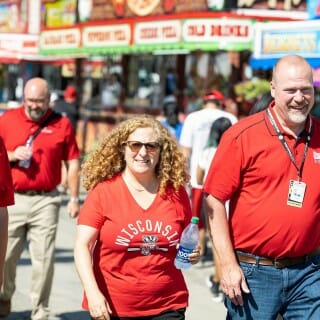 Chancellor Mnookin smiles and wears a red UW-Madison shirt as she walks through the Wisconsin State Fair Grounds