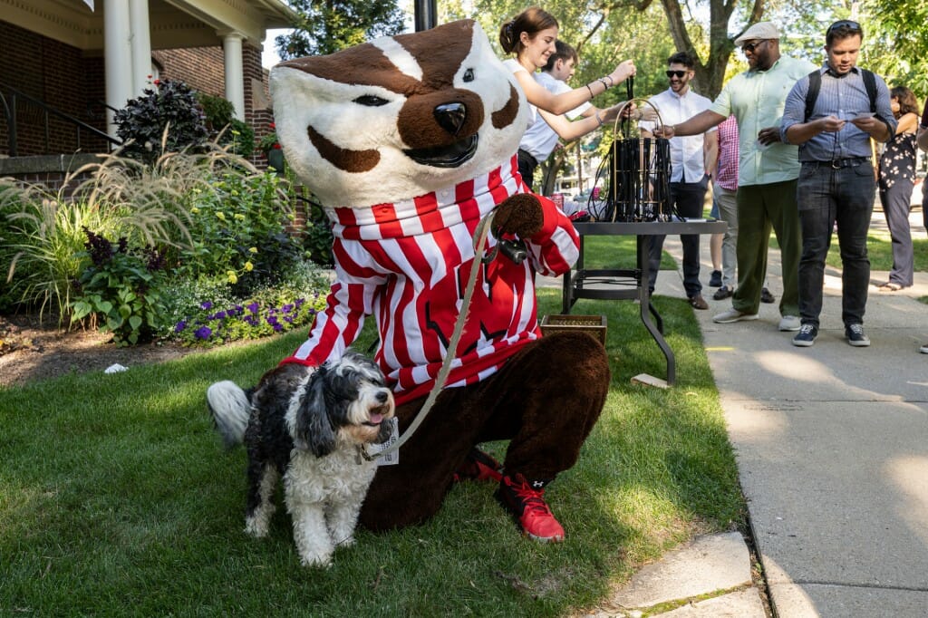 Bucky Badger keeps an eye on Chancellor Mnookin’s dog Plato as guests check in to the event. 
