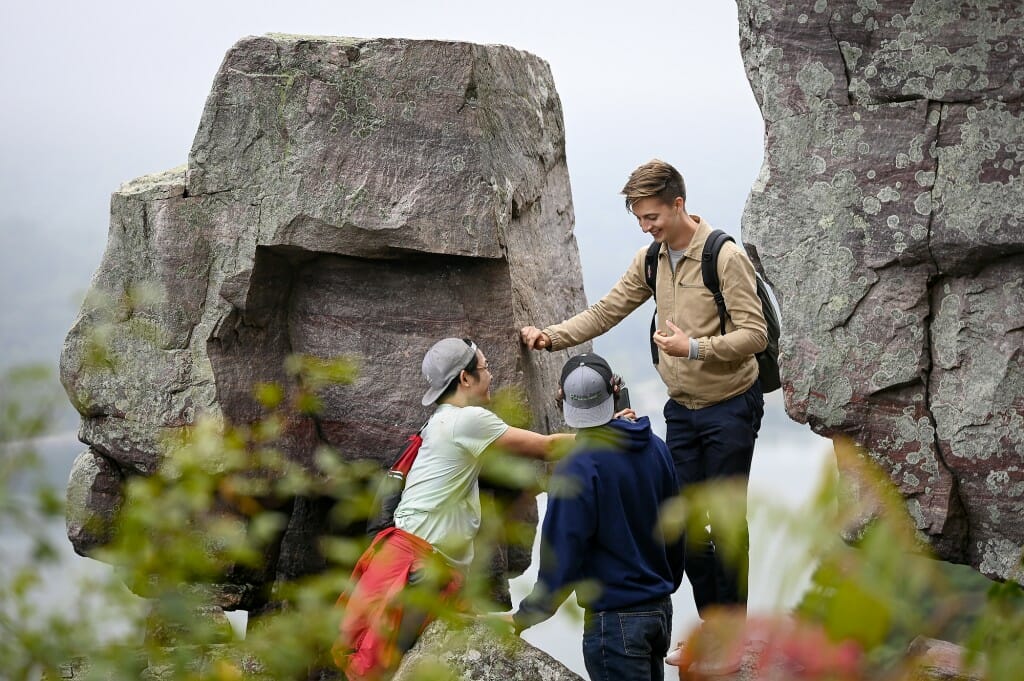 Three students explore a rock formation at a state park