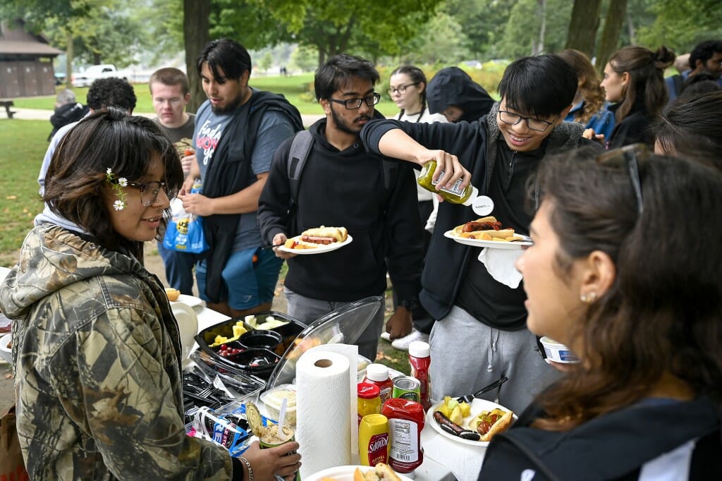 A group of students enjoy food at a cookout