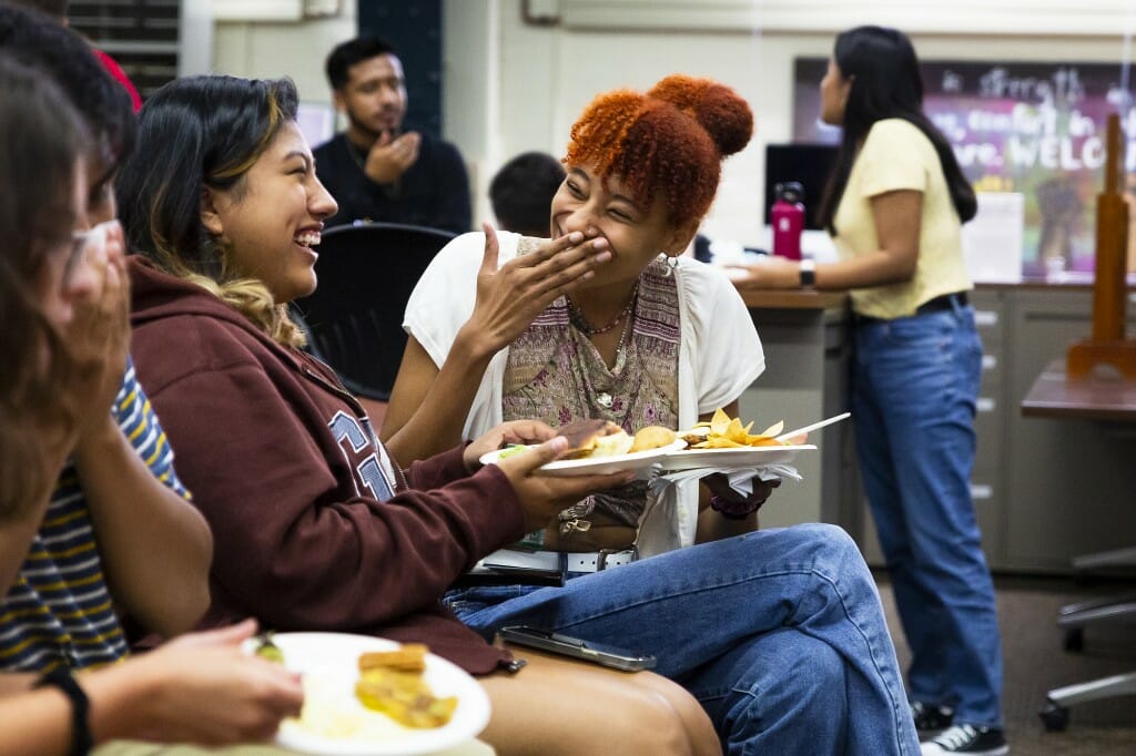 Students Yireisy Mancera (left) and Mariam Diaby (right) eat and talk together at the welcome event.