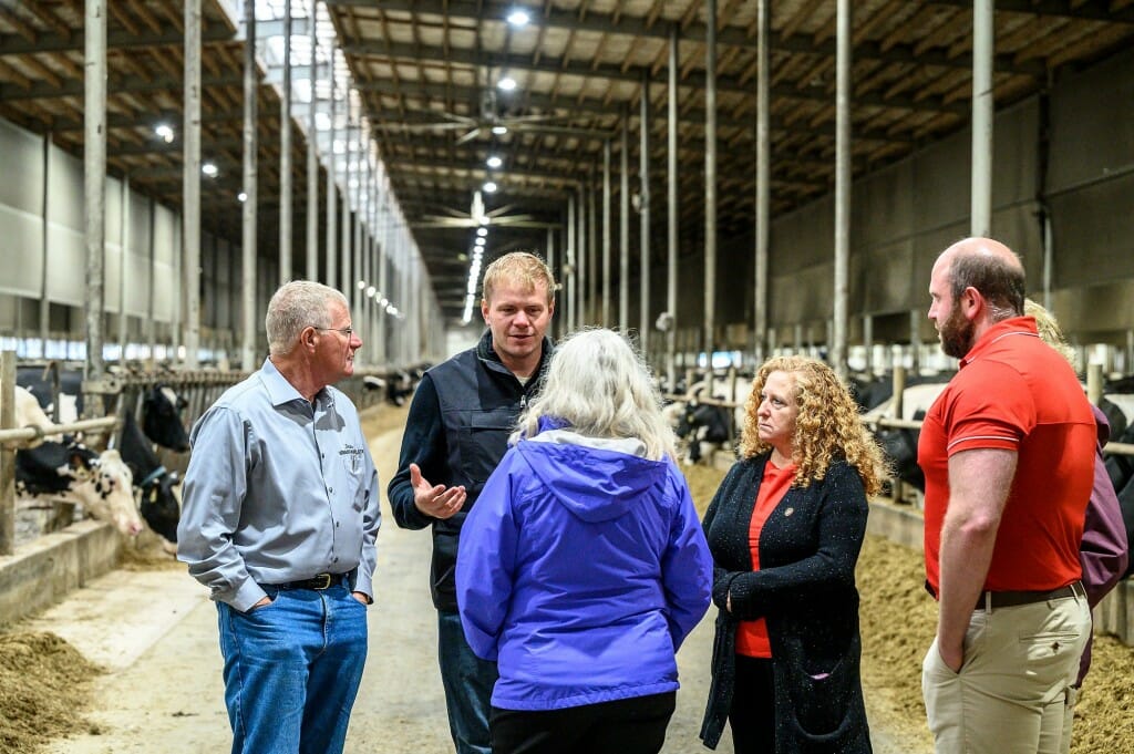 Second from right, Chancellor Mnookin listens to Ryan Schmidt talk about cow maternal health along with (counterclockwise) Sen. Howard Marklein; Glenda Gillaspy, dean of the College of Agricultural and Life Sciences; and Regan Schmidt, as the chancellor toured the Schmidt Dairy Farm.